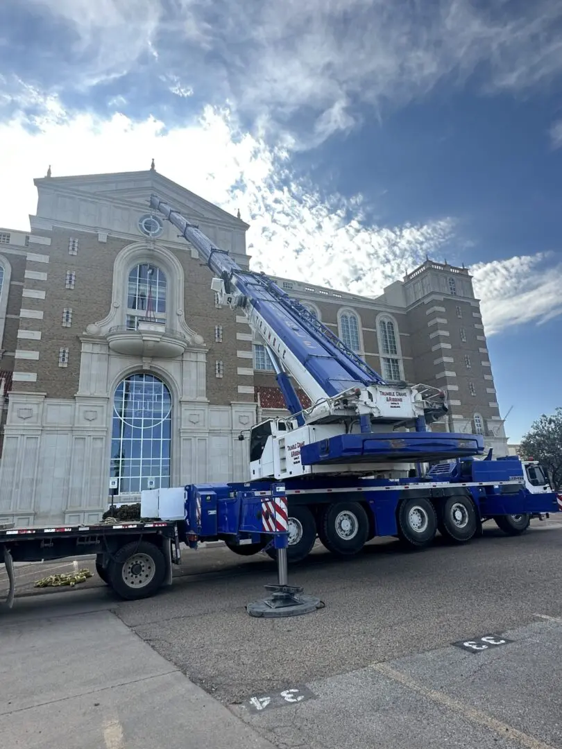 A crane is parked in front of a building.