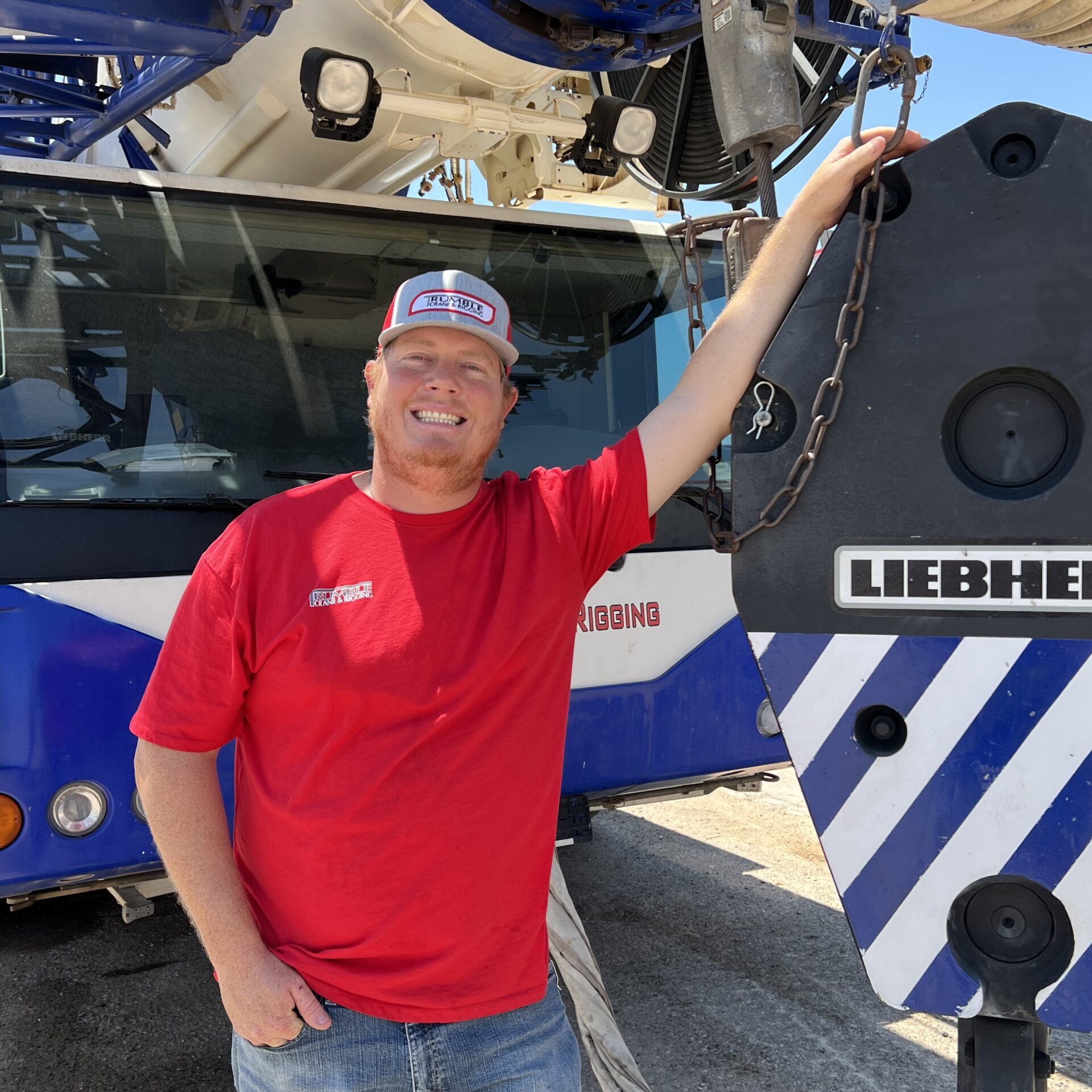 A man standing next to a large blue and white bus.