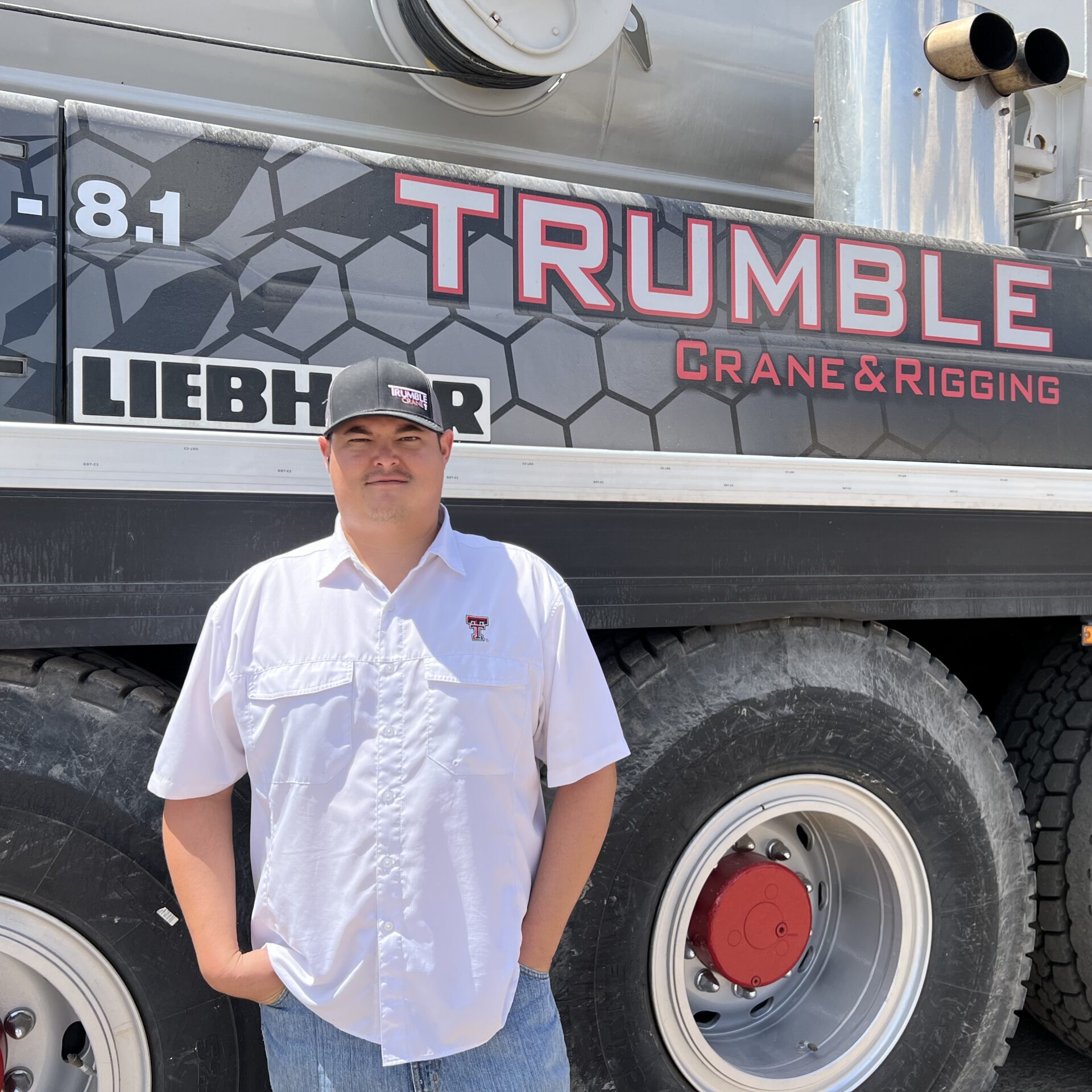 A man standing in front of a large truck.